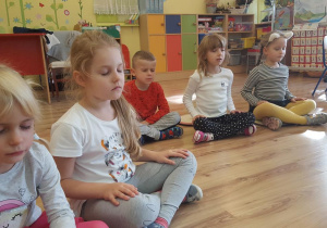 Dzieci biorą udział w ćwiczeniach relaksacyjnych.
